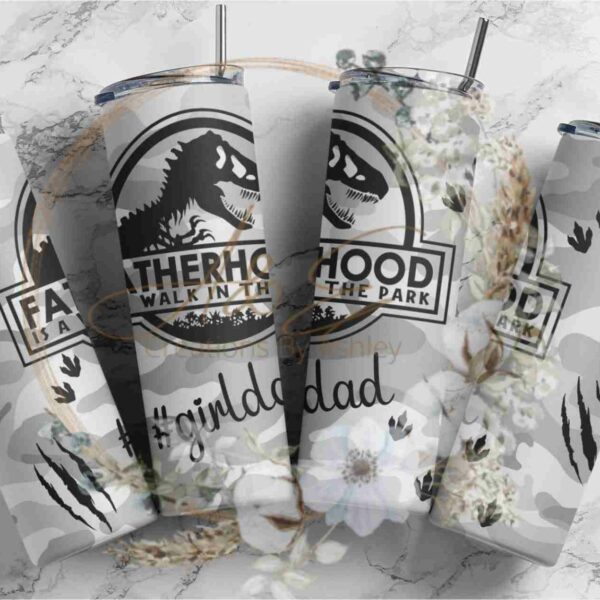 Four stainless steel tumblers with camouflage patterns and dinosaur graphics. Each tumbler has text: "Fatherhood is a walk in the park." The tumblers are arranged in a row, and one features the hashtag "#girldad.