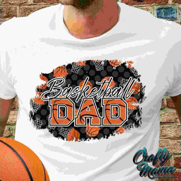 A close-up of a person wearing a white t-shirt with "Basketball Dad" written on it, surrounded by basketball-themed graphics in orange and black. The person holds an orange basketball.