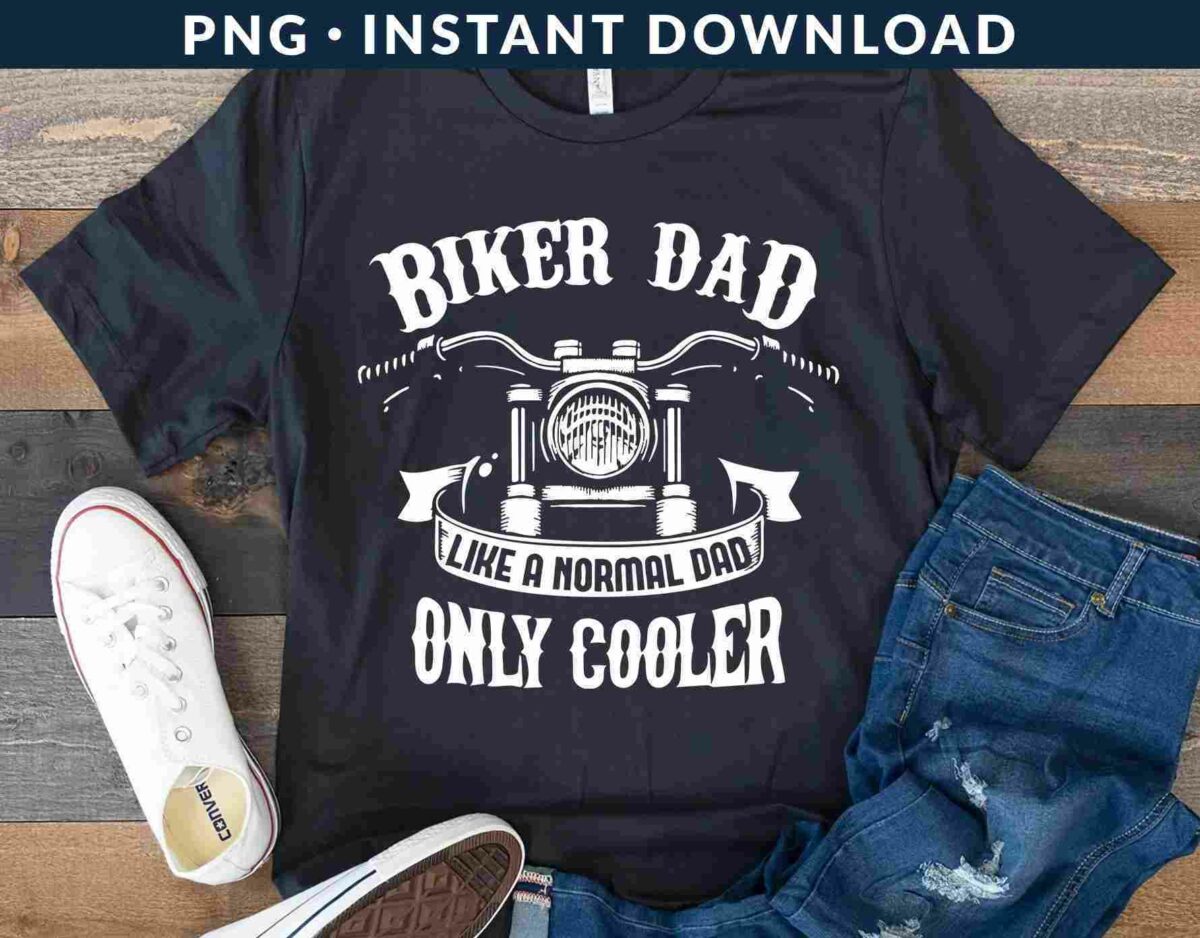 A black T-shirt with the text "Biker Dad Like a Normal Dad Only Cooler" featuring a motorcycle graphic. It's displayed with white sneakers and blue jeans on a wooden surface.