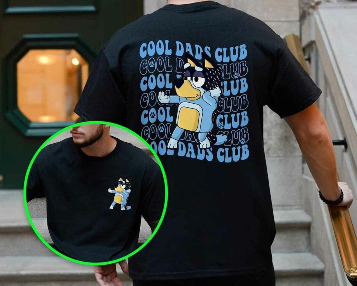 A person wearing a black T-shirt with a graphic of a cartoon dog and the text "Cool Dads Club" repeatedly printed on the back. An inset shows the front of the shirt with the same image in a smaller size.