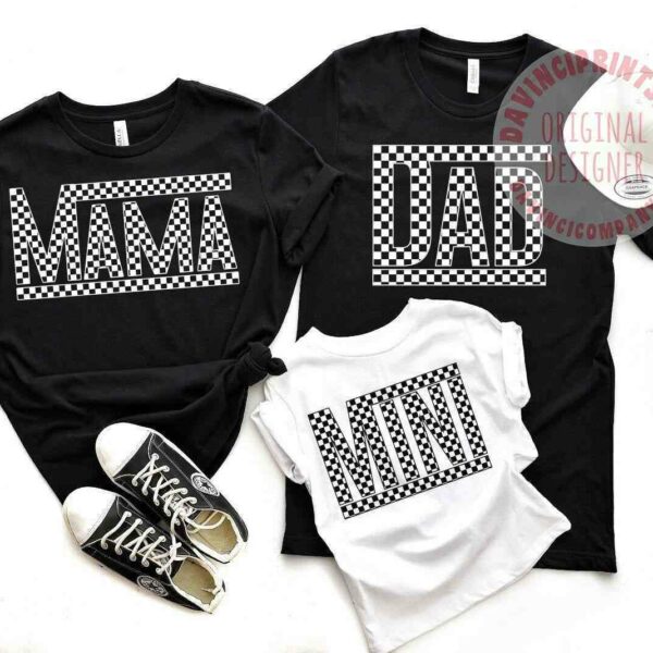 Two black shirts labeled "MAMA" and "DAD" and one white shirt labeled "MINI" are displayed alongside a pair of black sneakers with white laces.