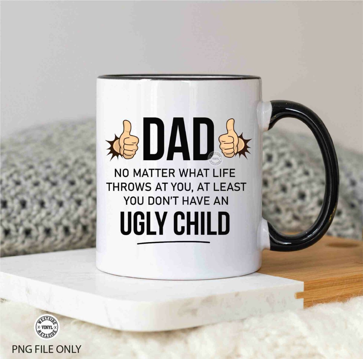 A white mug with a black handle that reads "Dad, no matter what life throws at you, at least you don't have an ugly child" with two thumbs-up icons.