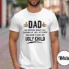 Alt Text: A man wearing a white T-shirt with the bold text: "Dad. No matter what life throws at you, at least you don't have an ugly child.