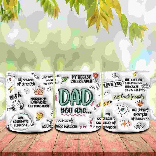 A multi-colored mug on a wooden surface with various phrases about dads, including "My source of strength," "My biggest cheerleader," "The captain," and "I love you," framed by a green leafy background.