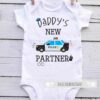 A white baby onesie with the text "Daddy's New Partner" featuring a graphic of a police car, a police hat, handcuffs, and a walkie-talkie.