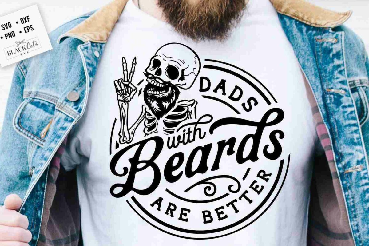 A person wearing a denim jacket and a white T-shirt with a graphic design of a skeleton holding up two fingers and text that reads, "Dads with Beards Are Better.