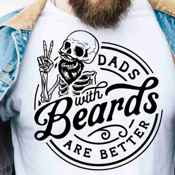 A person wearing a denim jacket and a white T-shirt with a graphic design of a skeleton holding up two fingers and text that reads, "Dads with Beards Are Better.