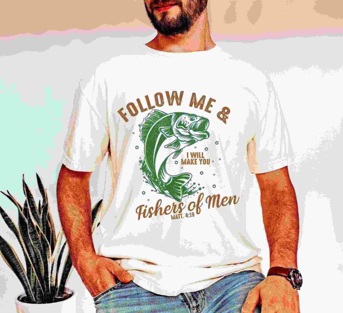 A man stands wearing a t-shirt with the text "Follow Me & I Will Make You Fishers of Men, Matt. 4:19" and a fish graphic.