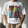 A person wearing a white t-shirt with a design featuring four men in different colored squares and the text "DAD Vibes.