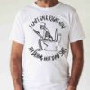 A person wearing a white t-shirt with an illustration of a skeleton sitting on a toilet while using a phone. The text on the shirt reads, "I can't talk right now, I'm doing hot dad shit.