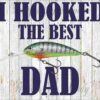 Alt Text: A fishing lure with the text "I Hooked the Best Dad" written in bold letters against a wooden background.