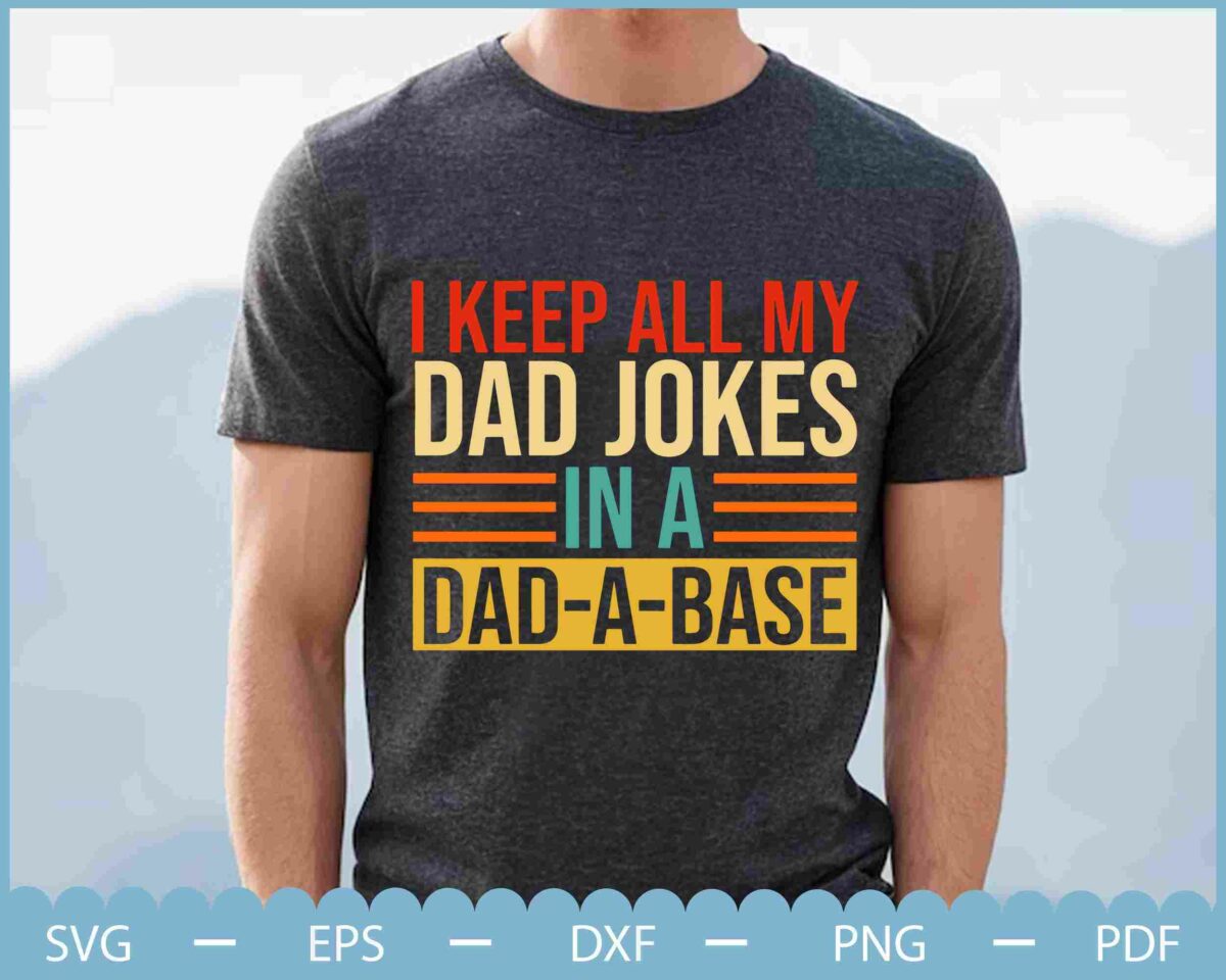 A person wearing a dark t-shirt with the text: "I keep all my dad jokes in a dad-a-base." The background is out of focus, showing an outdoor setting.