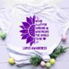 White T-shirt with a purple sunflower graphic, text reading “I wear purple for someone who means the world to me,” and “Lupus Awareness.” Decorated with eggs and foliage.