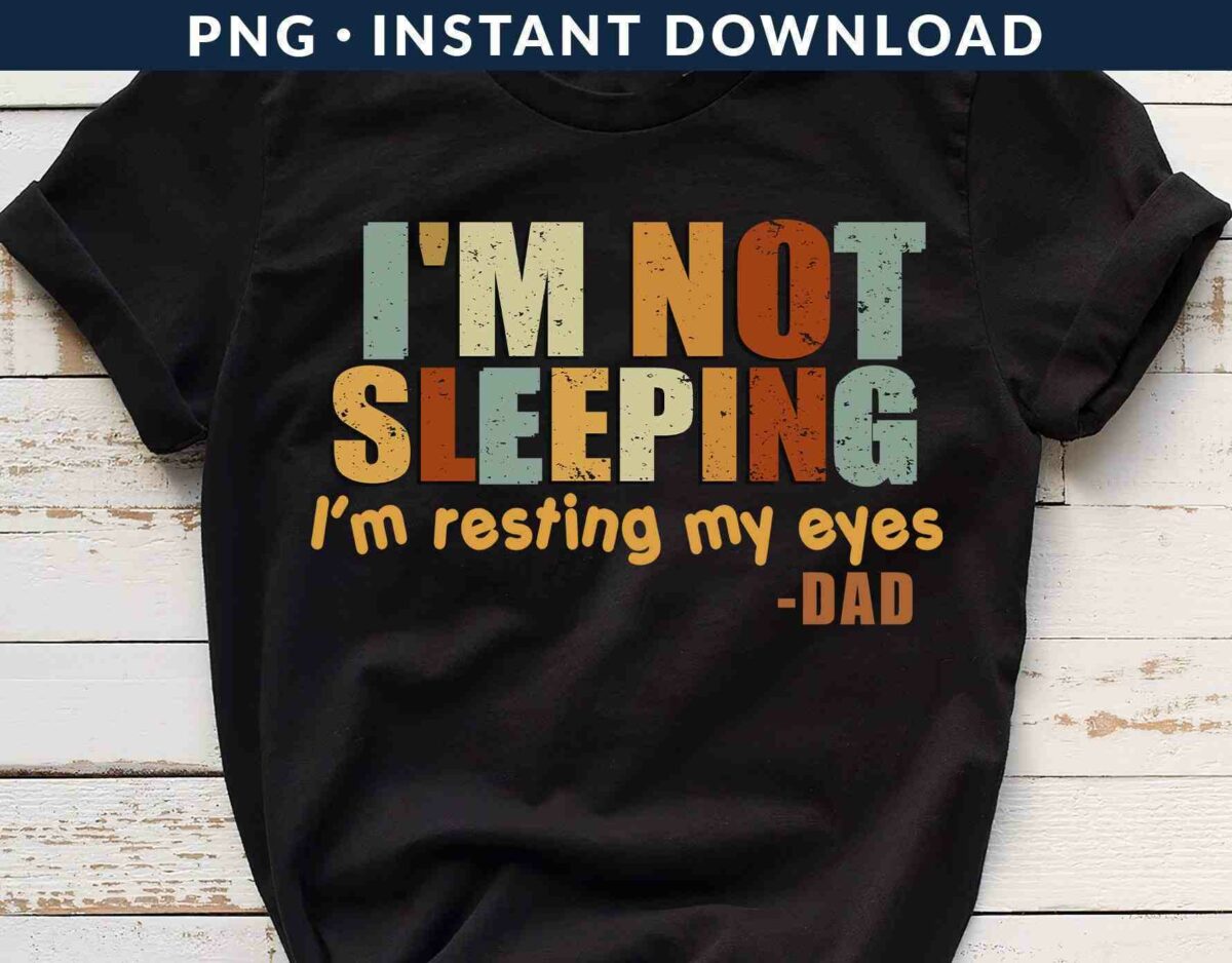 A black t-shirt with the text "I'M NOT SLEEPING, I'm resting my eyes -DAD" in bold, multicolored letters.