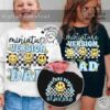 Two children wearing shirts with the phrase "Miniature Version of my Dad" and graphic designs, one in a white shirt and one in a black shirt. The image also shows a circular logo and website information.