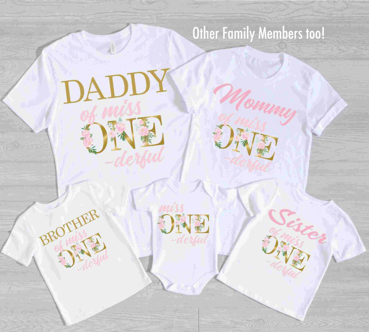 A set of five white shirts laid out, each with floral-themed text reading "Daddy of miss ONE-derful," "Mommy of miss ONE-derful," "Brother of miss ONE-derful," "Sister of miss ONE-derful," and "miss ONE-derful.