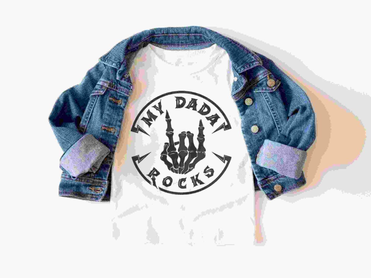 A white t-shirt with a skeleton hand graphic and the text "MY DADA ROCKS" is displayed under a blue denim jacket with rolled-up sleeves.