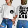 Two people wearing white t-shirts and blue jeans. One t-shirt has a small logo on the front and text on the back reading, "MY OTHER RIDE IS YOUR DAD.