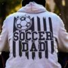 Back view of a person wearing a gray hoodie with an image of a soccer ball and the text "Soccer Dad" printed on the back.