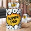 A mug on a table with a comic-style design and the text "Super Dad" in bold letters. Another similar mug is visible in the background.