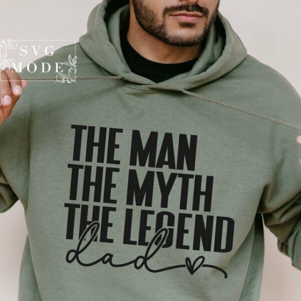 A person wearing a green hoodie with the text "THE MAN, THE MYTH, THE LEGEND, dad" written on it in black lettering.
